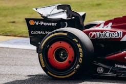 Close-up of a Ferrari Formula 1 car's rear wing and tire on the Interlagos track in São Paulo, Brazil.